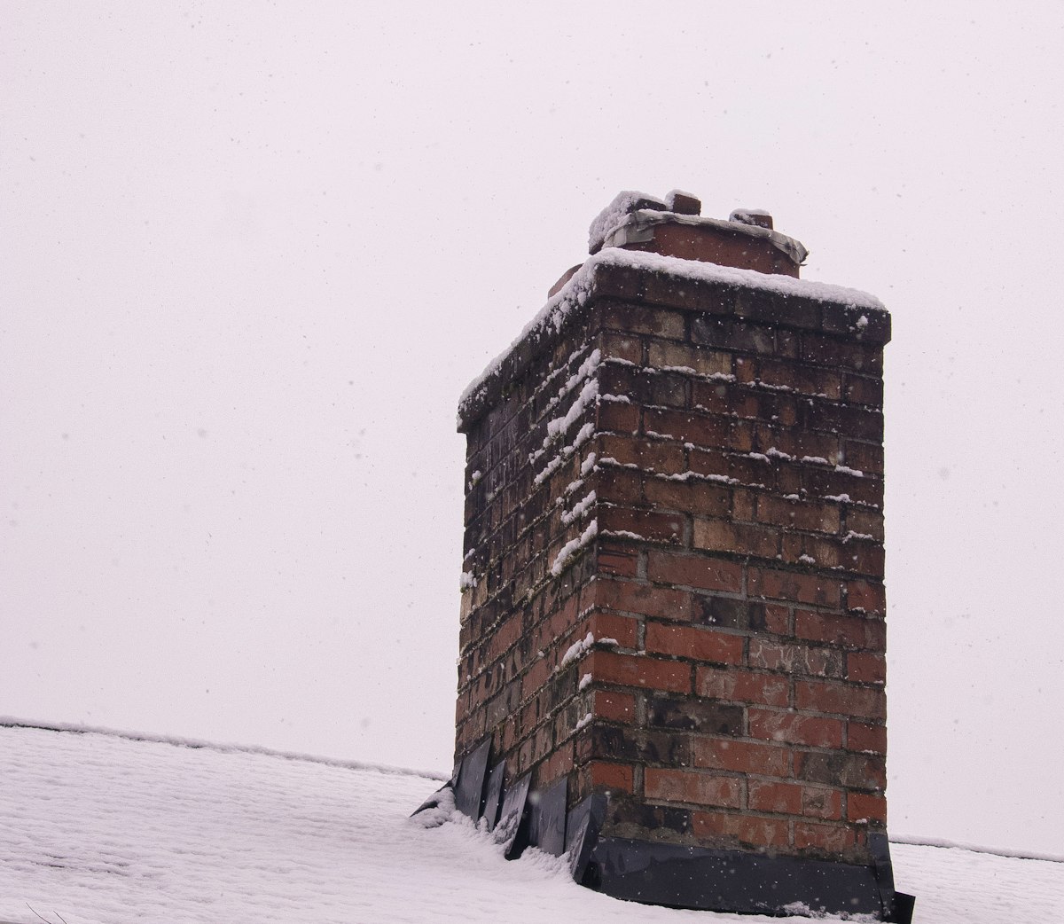 Brick fireplace with snow on chimney - woodburner efficiency in winter