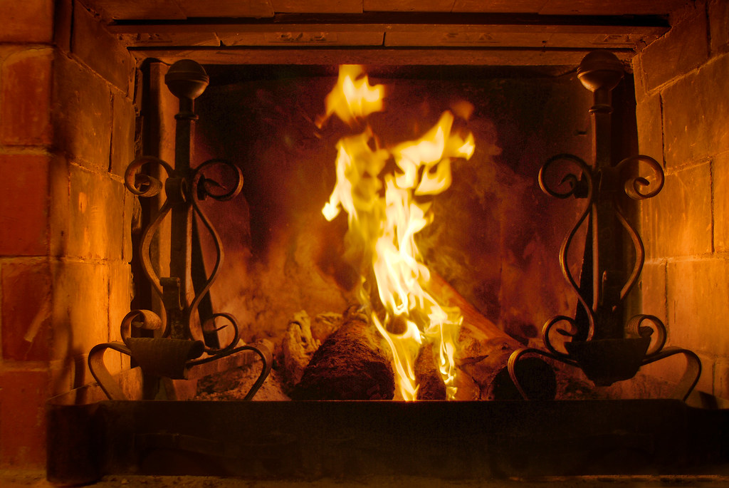 Brick fireplace with roaring flames - creosote removal prevents chimney fires